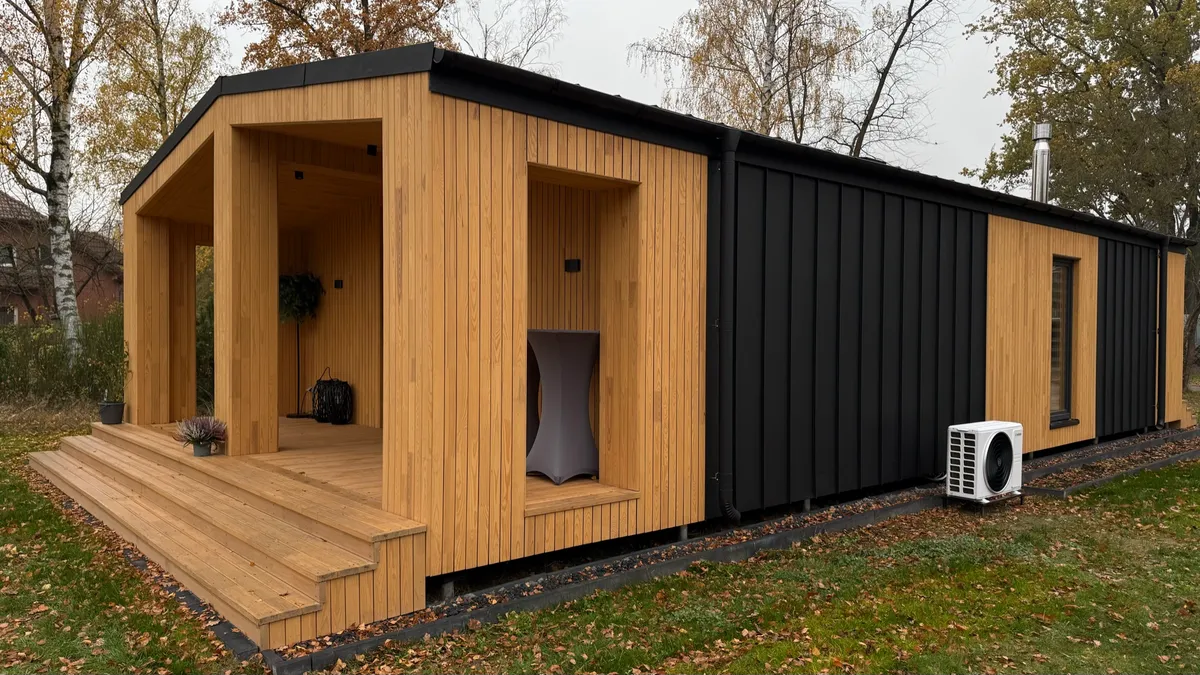 Schlüsselfertiges Modulhaus mit überdachter Terrasse und Wärmepumpe, wofür der Gesamtpreis eines Modulhauses kalkuliert wird
