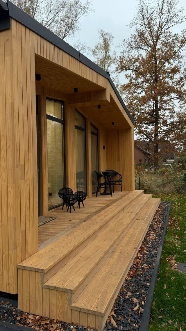 Schlüsselfertiges Modulhaus mit überdachter Holzterrasse als Beispiel für hochwertige, echte Bauqualität